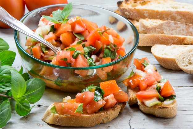 Ingredients to make bruschetta, typical italian appetizer with\
tomato, basil and toast