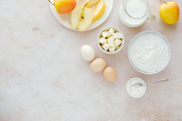 Ingredients for making apple pie flour milk eggs apples butter Vegan baking recipe flat lay