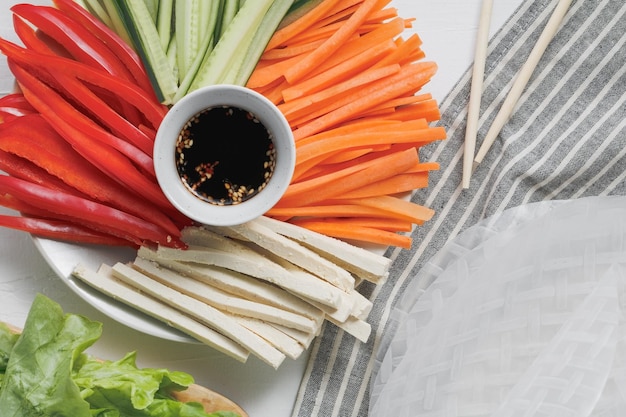 Photo ingredients for making asian fresh spring rolls raw cucumber carrot lettuce bell pepper tofu cheese inside rice paper top view