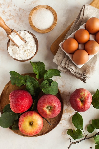 Ingredienti per fare la torta autunnale, charlotte come mele, farina, uova, zucchero.