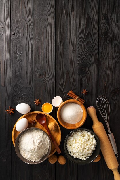 Ingredients for making buns with cottage cheese on a wooden background, top view, place for text