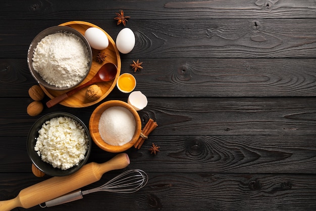 Ingredients for making buns with cottage cheese on a wooden background, top view, place for text