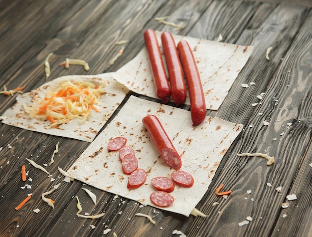 Foto ingredienti per fare i burritos, isolati su fondo di legno scuro.