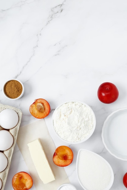 Ingredients for making classic cake pie with plums Concept homemade food seasonal pastries