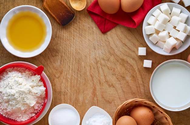 Ingredients for making pancakes on a wooden background