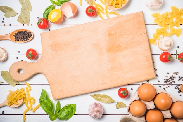 Ingredients for making pasta with chopping board at center