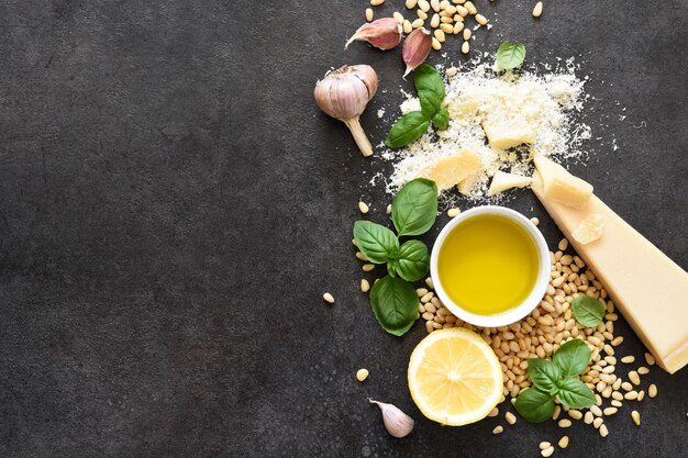 Ingredienti per fare il pesto su uno sfondo di cemento nero. vista dall'alto. processo di cucina.