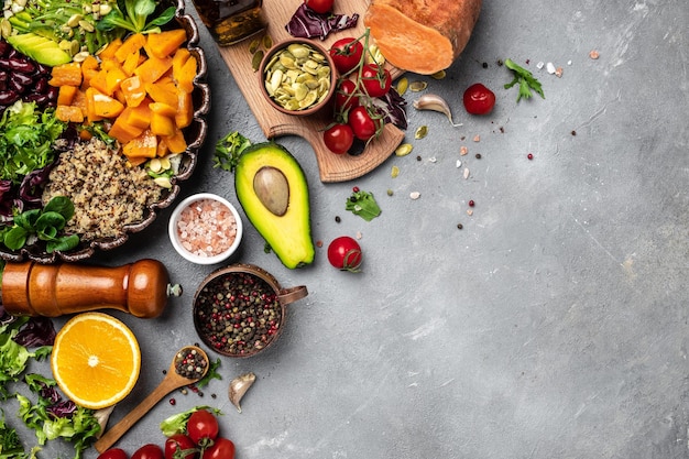 Ingredients for making Quinoa salad on gray background Vegetable salad in bowl avocado sweet potato beans herbs Clean healthy detox eating Vegan vegetarian food Making healthy salad top view