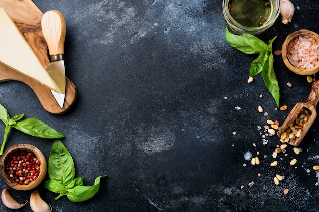 Ingredients for making traditional italian pesto sauce on old dark rustic background. Flat lay.