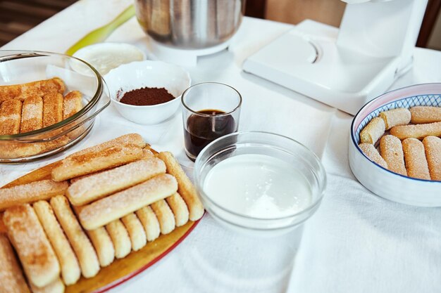 Ингредиенты для приготовления традиционного итальянского сладкого торта тирамису печенье савоярди крепкий сладкий эспрессо кофе какао порошок сыр маскарпоне и свежие сливки