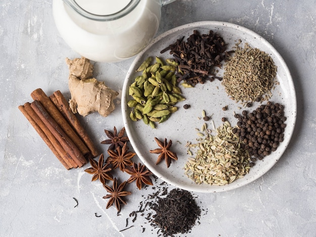 Ingredients for masala tea on grey. Top view