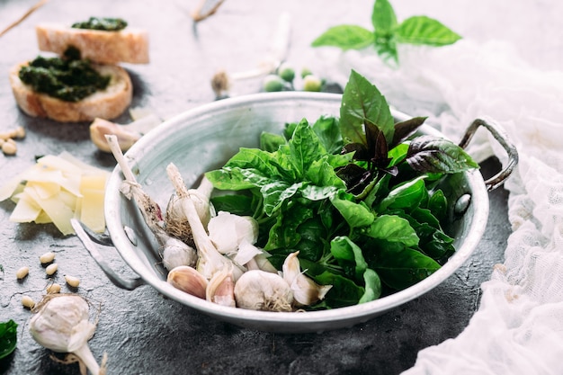 Ingredients for pesto sauce on a gray background Basil garlic parmesan pine nuts