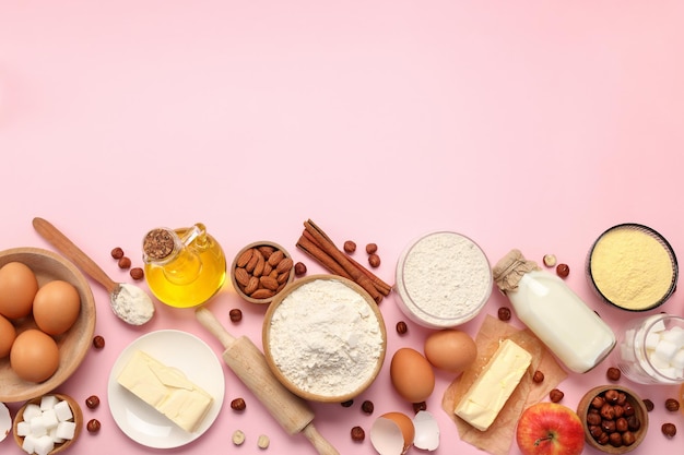 Ingredients for pie or cake cooking on pink background