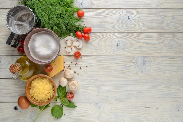 Ingredients for pizza on a wooden background top view