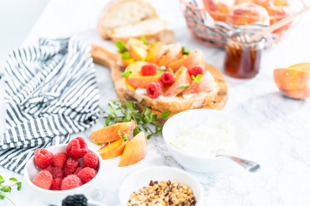 Ingredients for preparing peach ricotta toast on a marble countertop.