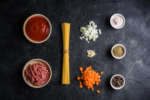 Ingredients for simple pasta bolognese on concrete background. View from above