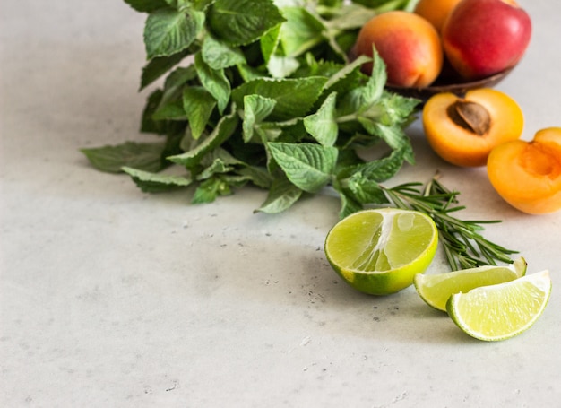 Ingredients for smoothie or cocktail (apricots, lime, mint and rosemary).