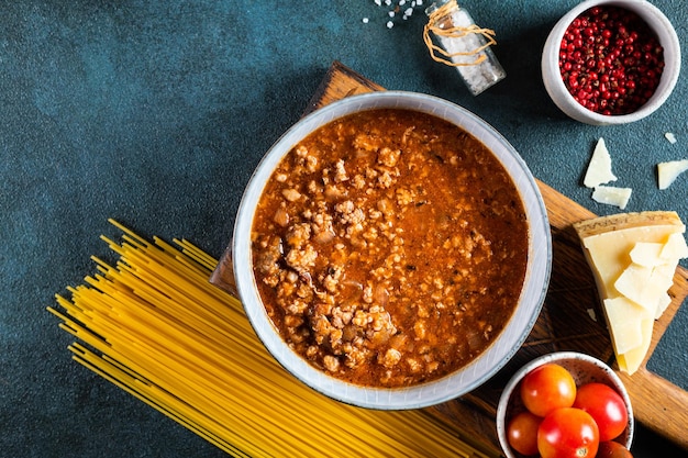 Photo ingredients for spaghetti bolognese on dark background raw pasta bolognese pasta flatlay italian bolognese food ingredients pasta top view