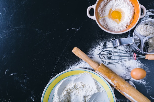 Ingredients and utensil for baking on the black board, top view