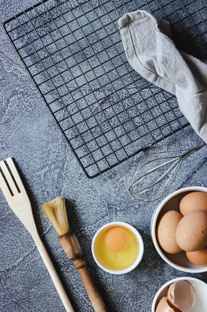 青い表面にケーキを準備するための食材や調理器具。卵、小麦粉、シナモン、牛乳。スペースをコピーします。