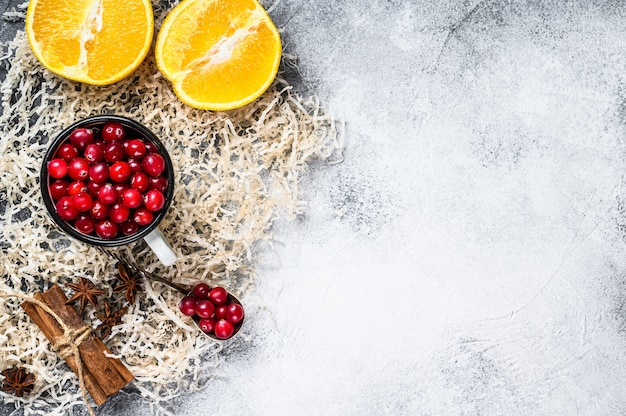 Ingredients for winter baking cookies. gingerbread, fruitcake, drinks. cranberries, oranges, cinnamon, spices. christmas food. gray background. top view. space for text