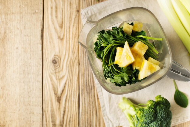 Ingrediets for green smoothie parsley spinach broccoli and celery on wooden table