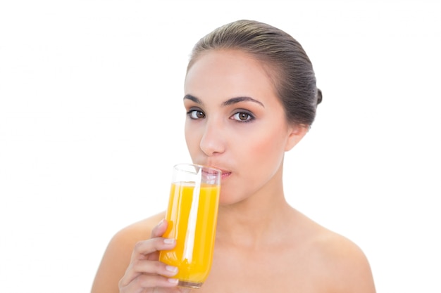Inhouds donkerbruine vrouw die een glas jus d&#39;orange drinkt