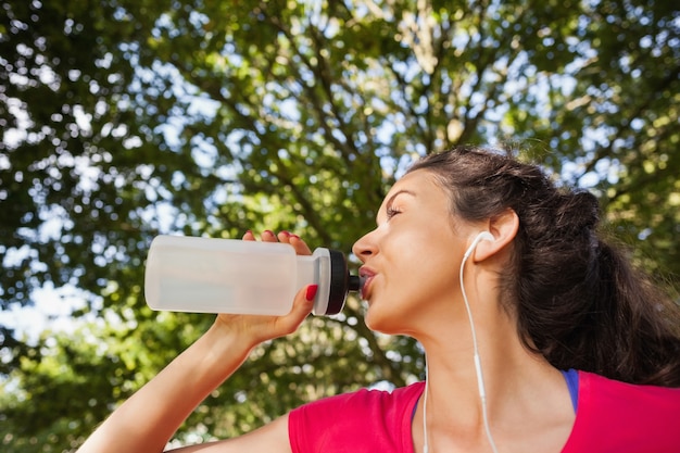 Inhouds sportieve vrouw die wat water drinkt