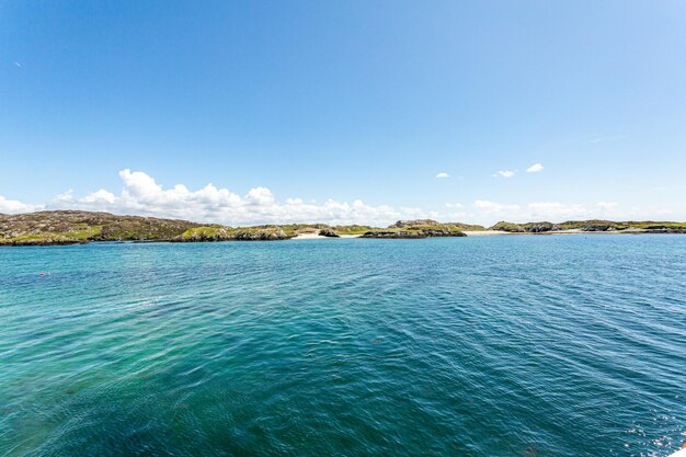 写真 アイルランドのイニッシュボフィン島の海岸景色 背景のビーチと小さな丘