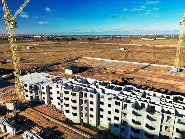 The initial stage of construction of a prefabricated reinforced\
concrete house assembly of a panel house shooting from a drone\
modern construction construction site closeup view from above