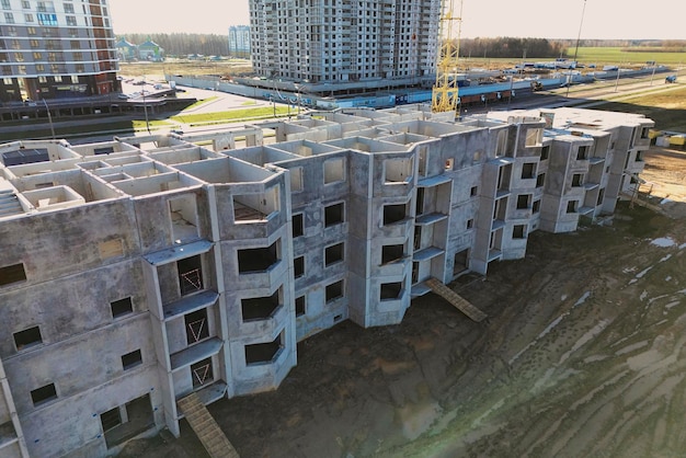 The initial stage of construction of a prefabricated reinforced\
concrete house assembly of a panel house shooting from a drone\
modern construction construction site closeup view from above