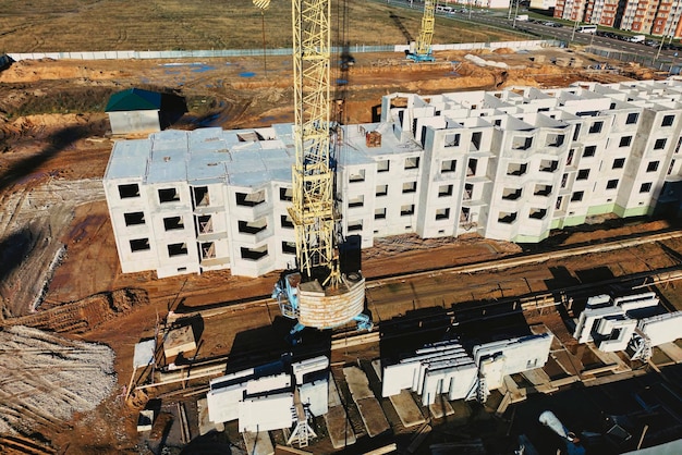 The initial stage of construction of a prefabricated reinforced concrete house Assembly of a panel house Shooting from a drone Modern construction Construction site closeup View from above