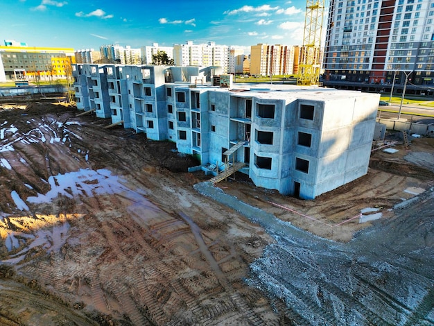 The initial stage of construction of a prefabricated reinforced\
concrete house assembly of a panel house shooting from a drone\
modern construction construction site closeup view from above