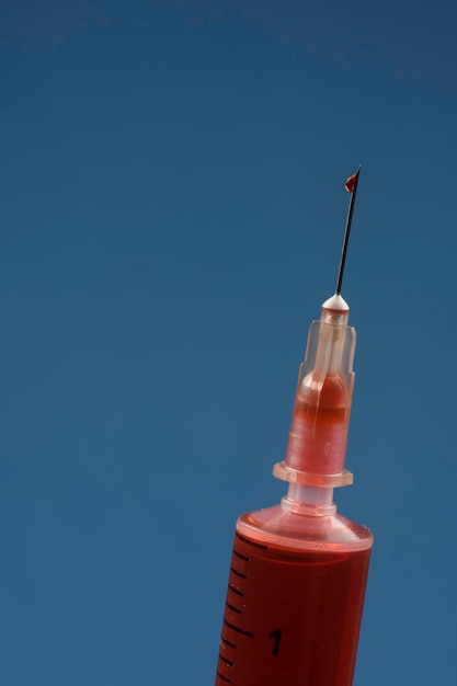 Injectiespuit met nadeldetail op gekleurde achtergrond met ruimte voor tekst