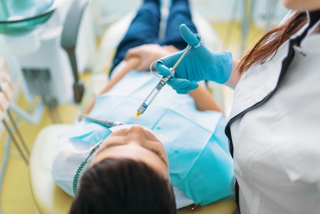 Injection of anesthesia, boy in dental chair