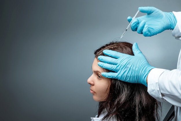 Iniezione per la crescita dei capelli, le mani del dottor krupnypy lan fanno un'iniezione, un'iniezione nella testa di una ragazza per perdita di capelli. salute, cura del corpo, stile di vita.