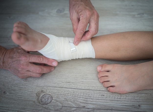 Photo injured foot on a wooden floor background