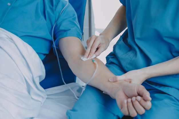 injured patient showing doctor broken wrist and arm with bandage in hospital office or emergency room sprain stress fracture or repetitive strain injury in hand nurse helping customer first aid