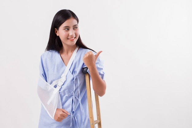 Injured woman patient pointing thumb up gesture away