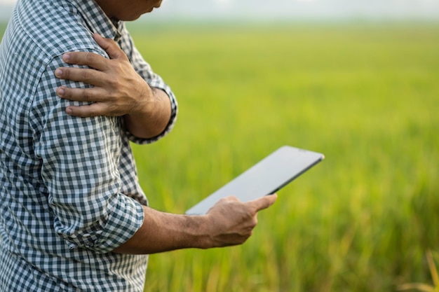 Injuries or Illnesses that can happen to farmers while working Man is using his hand to cover over elbow because of hurt pain or feeling ill