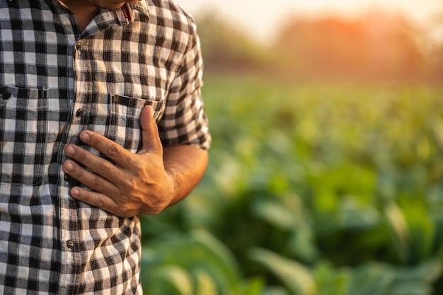 Injuries or Illnesses that can happen to farmers while working Man is using his hand to cover over left chest because of hurt pain or feeling ill