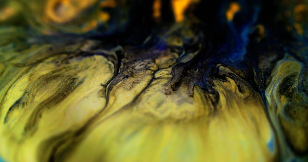 Foto ink spill glitter vloeibare textuur defocused zwart blauw geel kleur metaal glanzend gouden stof