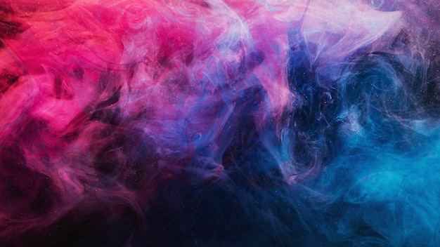 Ink in water. Colorful background. Glowing steam cloud texture. Contrast bright blue purple magenta pink glitter vapor wave on dark.