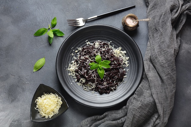 Inktvisinktpasta met parmezaan, basilicumblaadjes. Zwarte spaghetti