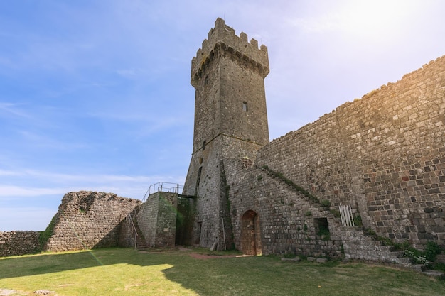 Inner yard of Radicofani fort ruins with a Tower on blurry sky background Tuscany Italy Val d'Orcia