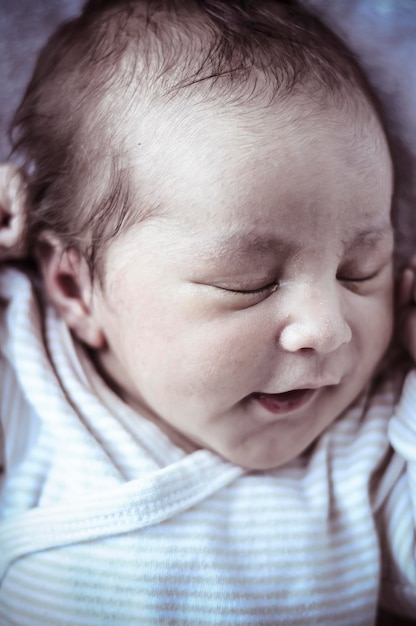 Photo innocence, new born baby curled up sleeping on a blanket, multiple expressions