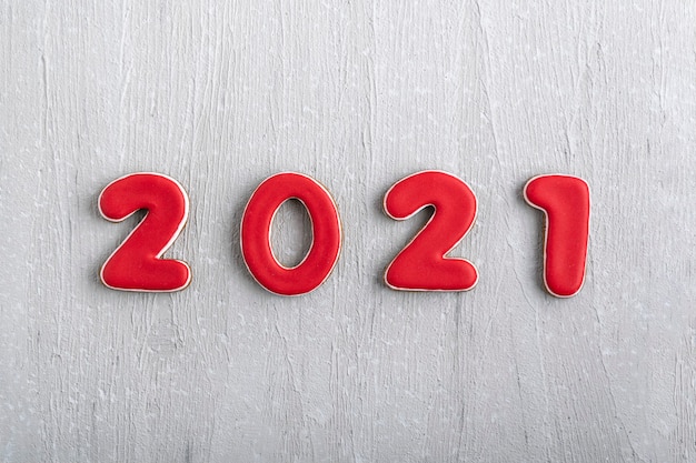 Inscriptie in rode cijfers 2021 van peperkoek op grijze achtergrond. Nieuwjaar 2021.