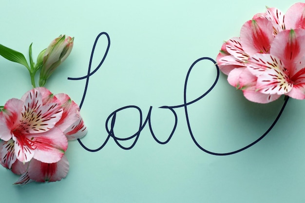 Foto inscriptie liefde met roze bloemen op groene achtergrond
