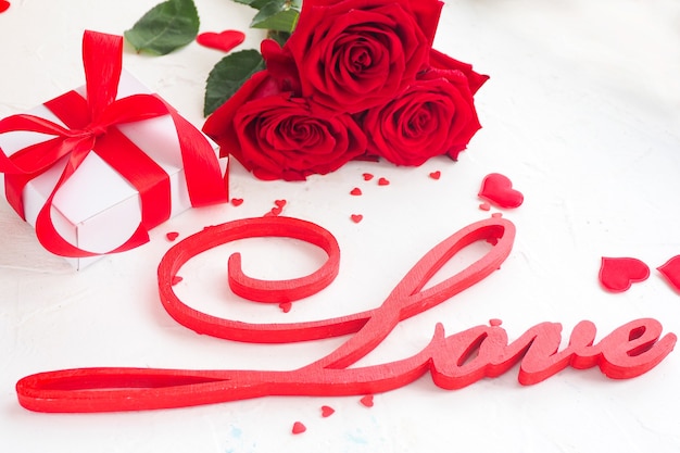 Inscriptie liefde met rozen en geschenkdoos