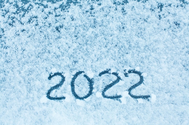 Inscriptie op de sneeuw 2022. Koud weer. Toerisme in de winter. Ruimte kopiëren.